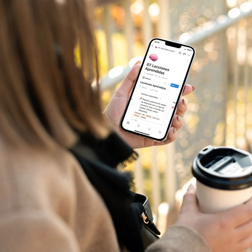 Mujer sosteniendo un café y un teléfono con una plantilla descargable