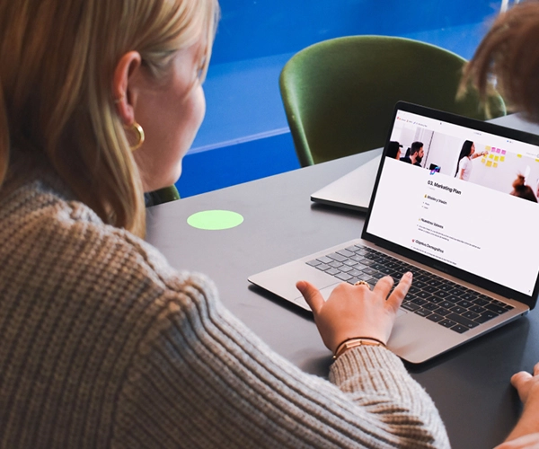 Mujer usando una laptop con una plantilla descargable